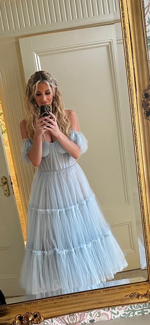 Selena, a light blue tulle midi with a semi transparent corset bodice and puff tulle cap sleeves.