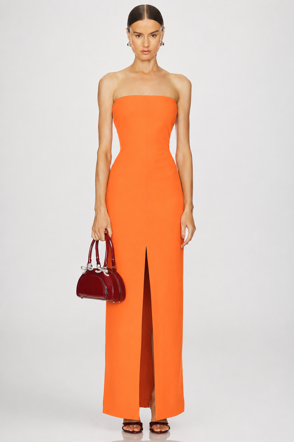 Simone, an orange maxi with a strapless neckline and a structured bodice, cut close to the body.