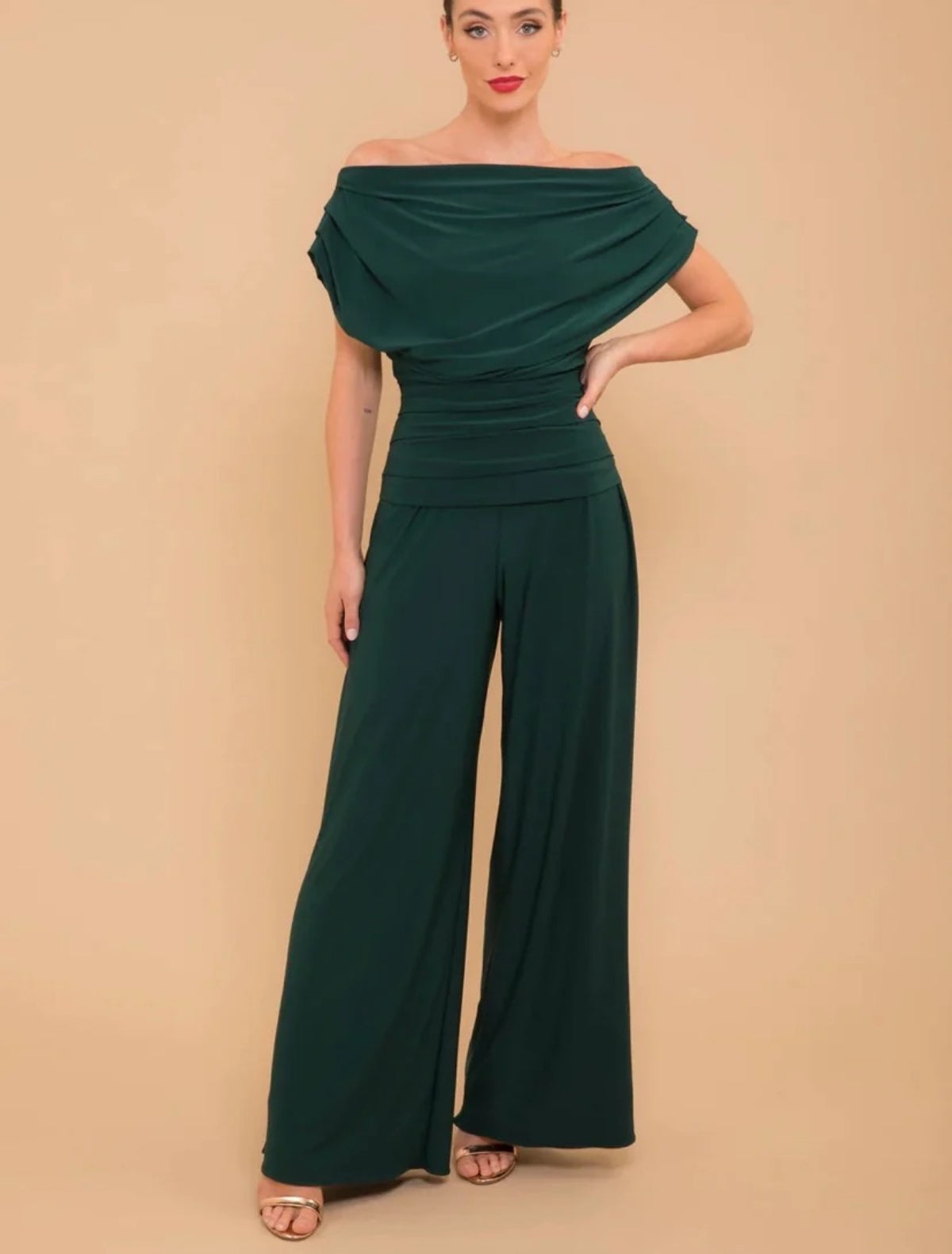 Talia, a forest green jumpsuit in a soft stretch fabric, with an off the shoulder Bardot neckline.