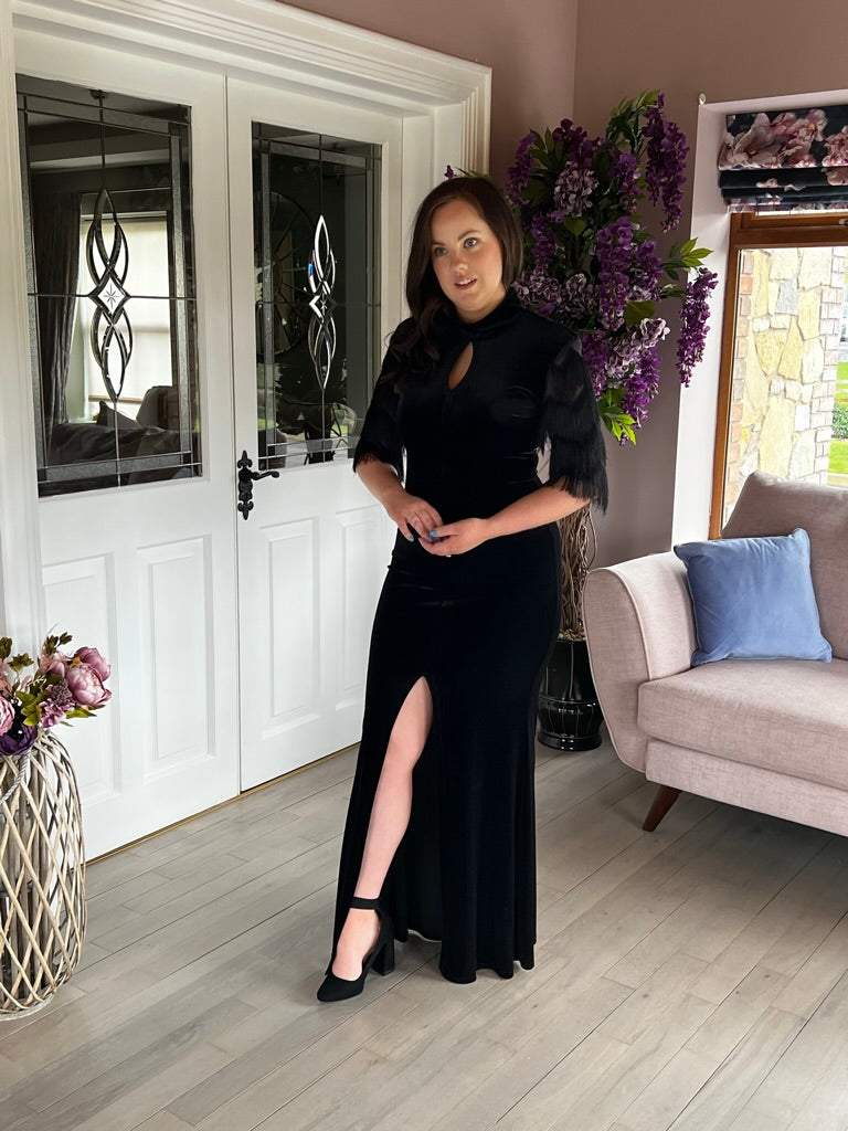Aria, a rich black velvet gown with a high neck and a keyhole at the front.