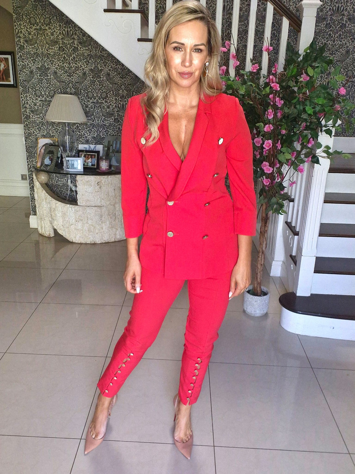 Zoe, a coral two piece with a slightly oversized jacket and polished gold hardware, in a structured fabric.